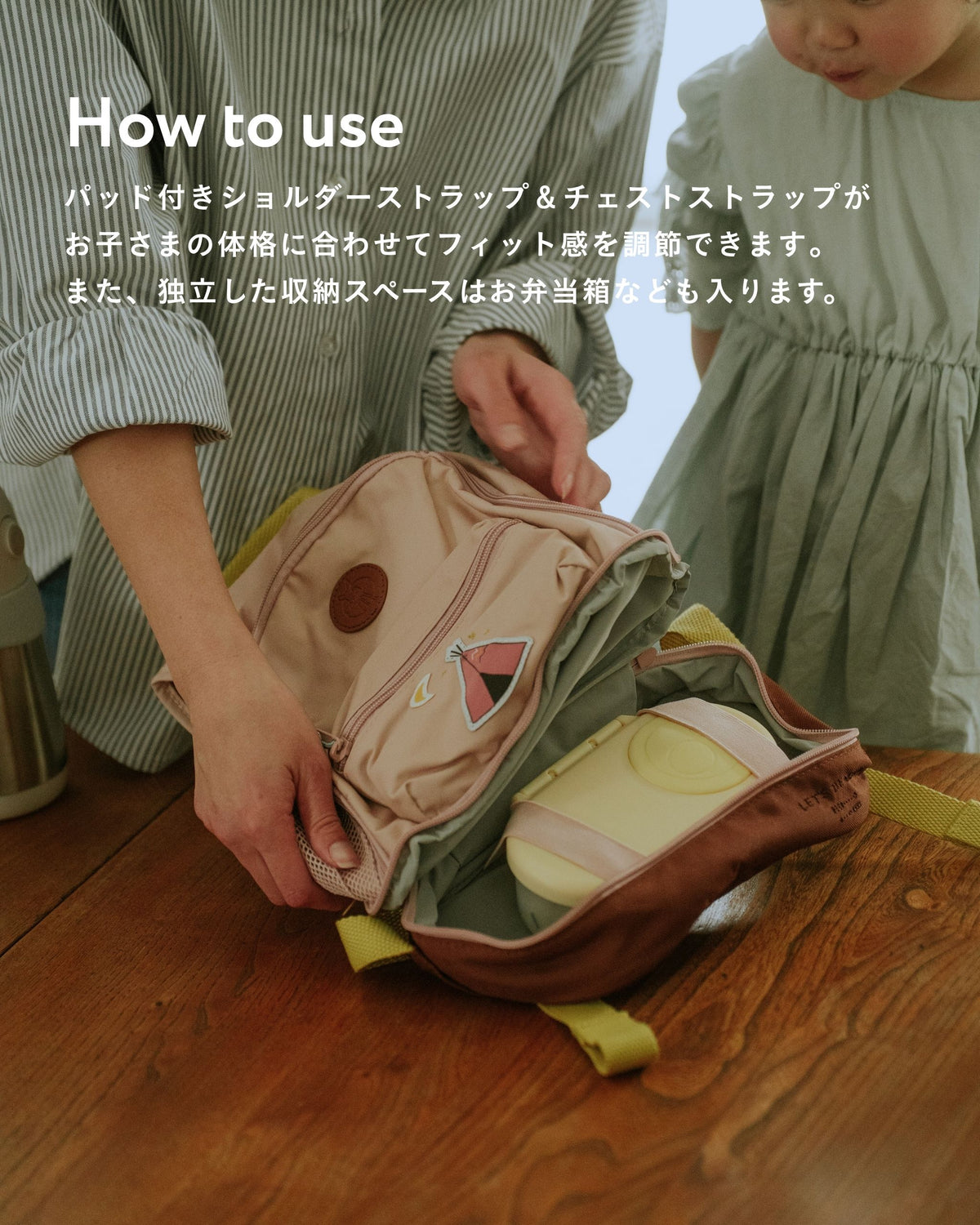 ピンクのミニバックパックの底部収納に水筒を入れる場面