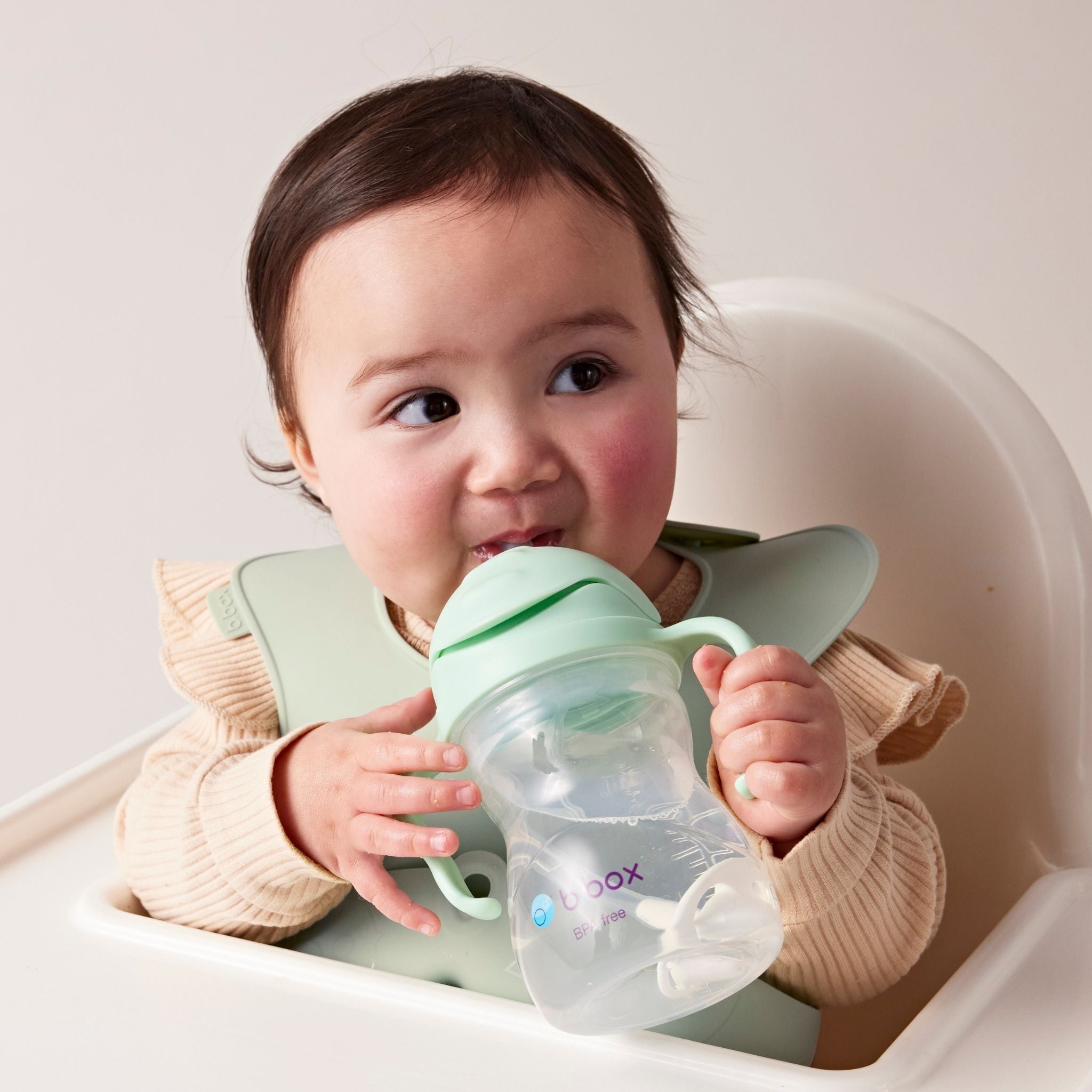 ビーボックスのシッピーカップとシリコンビブを使用している女の子の赤ちゃんの様子